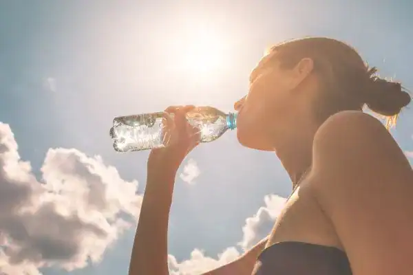 Hydration: The Secret Ingredient for a Toned Stomach and Enhanced Fitness 3 Image of woman drinking water to hydrate Dunstable after run.